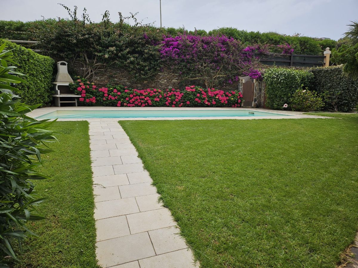 Piscina con ortensie e prato
